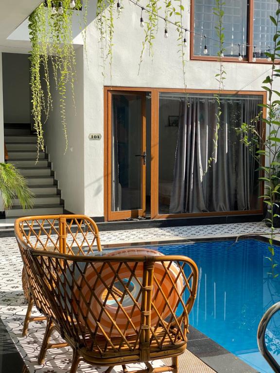 a wicker chair sitting next to a swimming pool at Hang Mua Boutique in Ninh Binh
