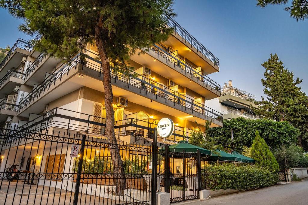 un edificio de apartamentos con balcón y un árbol en Genesis Hotel, en Loutraki