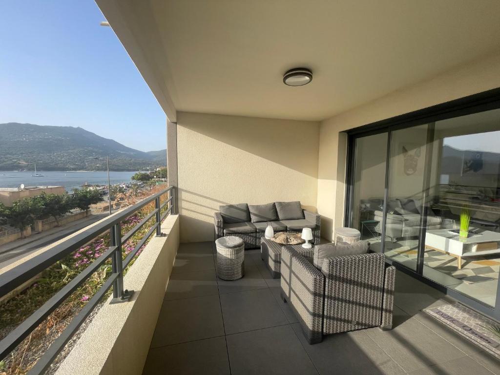 a balcony with couches and a view of the ocean at Splendide T3 neuf au bord de la plage in Propriano
