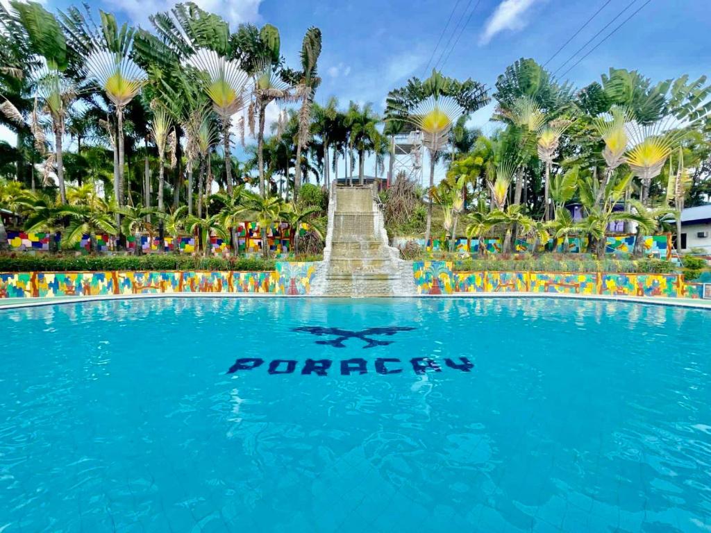 a swimming pool with a sign in front of a fountain at Poracay Resort powered by Cocotel in Porac