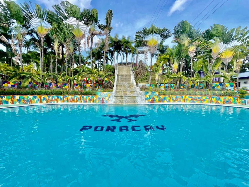 une piscine avec un panneau en face d'une fontaine dans l'établissement Poracay Resort powered by Cocotel, à Porac
