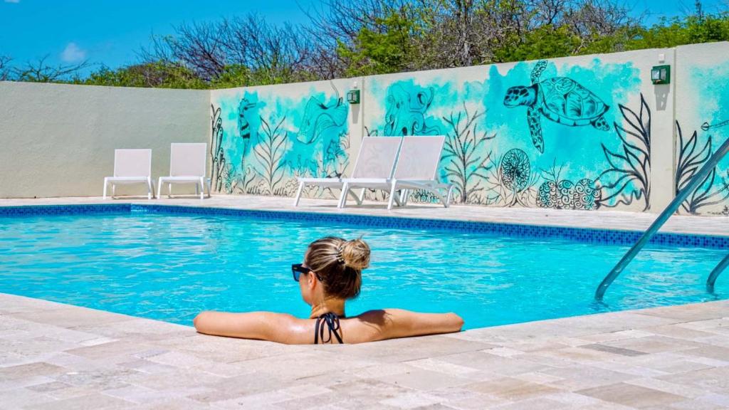 una mujer en bikini sentada en una piscina en Dream of the Green Flamingo, en Willibrordus