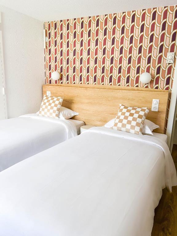 two beds sitting next to each other in a room at Kyriad Cannes - Mandelieu in Cannes