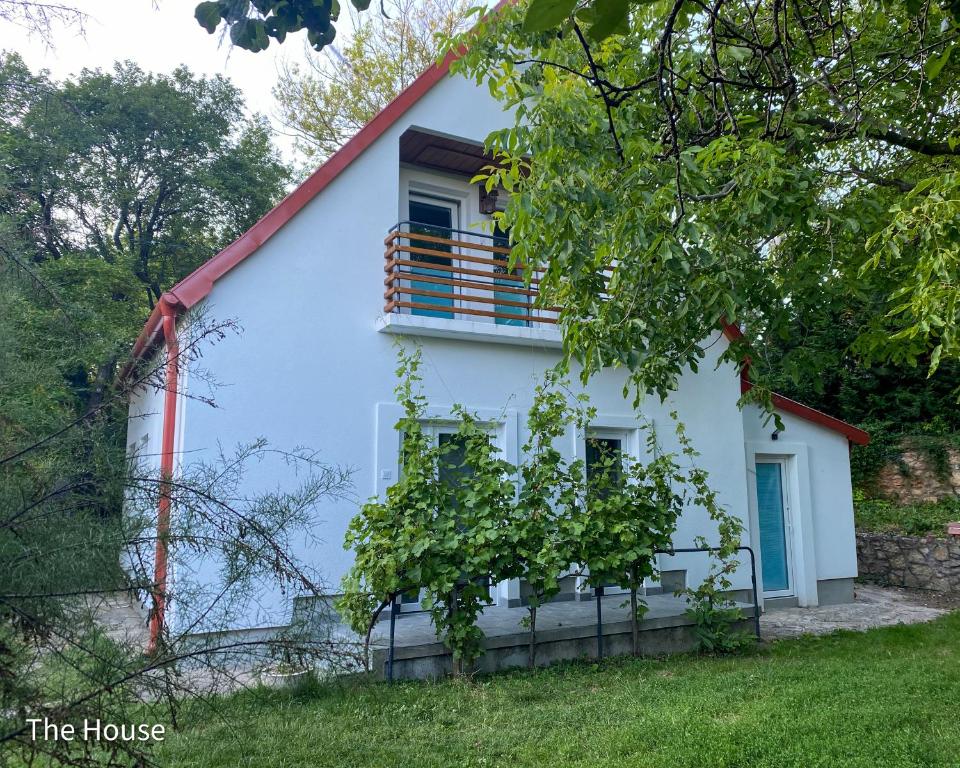 a white house with a red roof and a window at Quiet, green, relaxing place- 3 bedroom villa in Balatonfüred