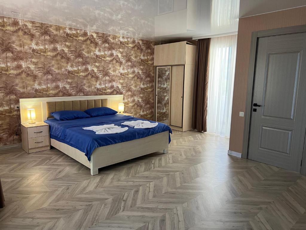 um quarto com uma cama azul e piso em madeira em villa with beautiful view 3 em Tbilisi