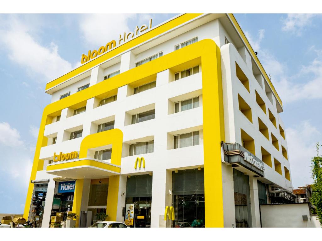 un edificio giallo e bianco con un cartello sopra di Bloom Hotel - Jammu a Jammu
