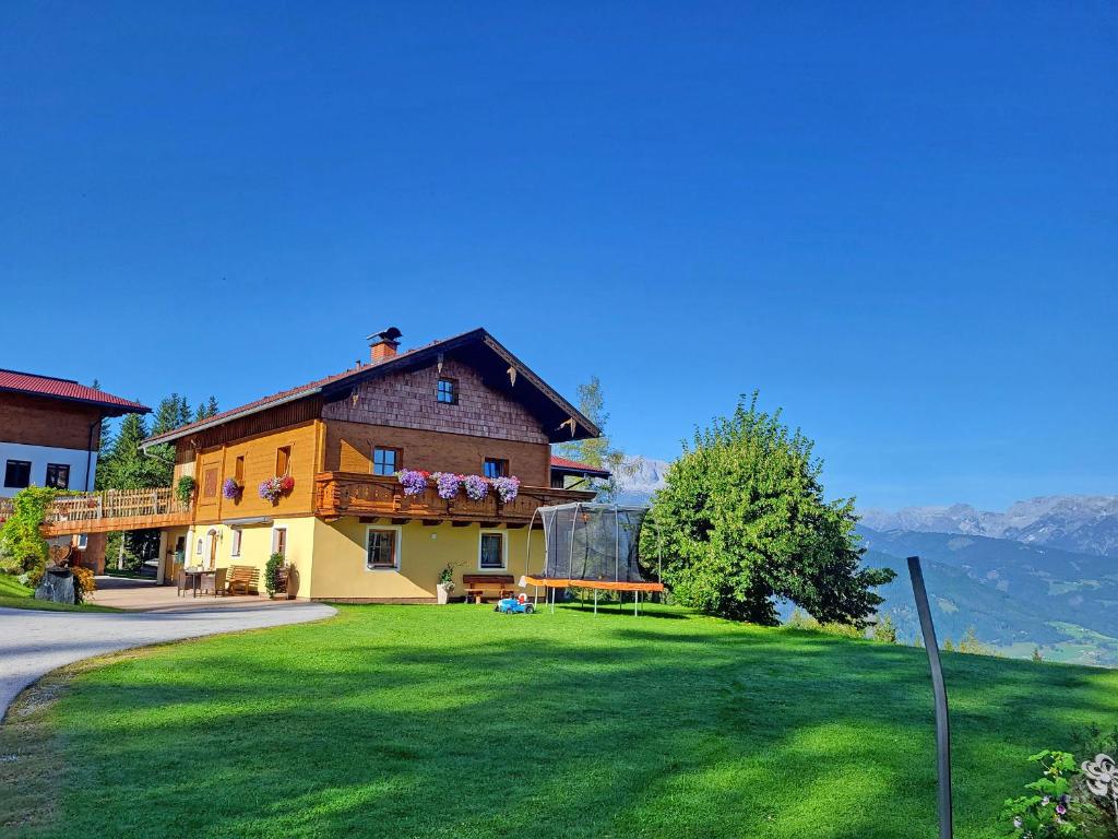 ein Haus mit grünem Rasen davor in der Unterkunft Almliesl BHOF-676 in Bischofshofen