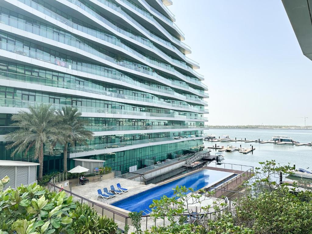 um grande edifício com uma piscina em frente em The Bay Watchers Abu Dhabi 203NB em Abu Dhabi