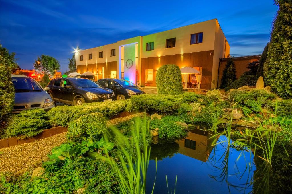 a building with cars parked in a parking lot at Confero Nowa Baśń in Nysa