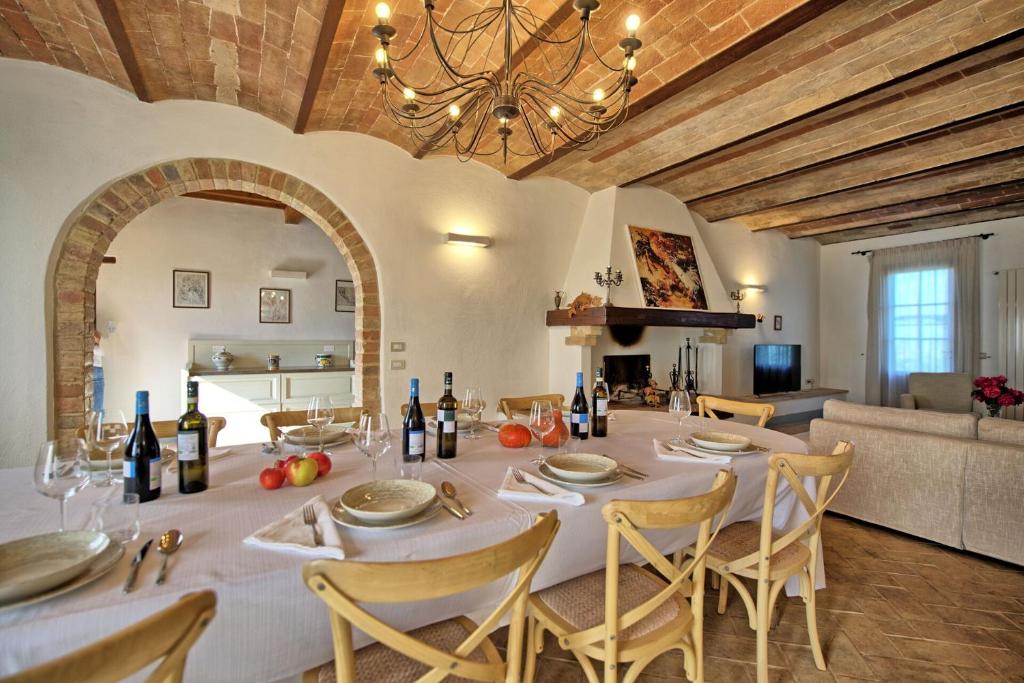 jadalnia z białym stołem i krzesłami w obiekcie Villa Il Caggio by PosarelliVillas w mieście San Gimignano