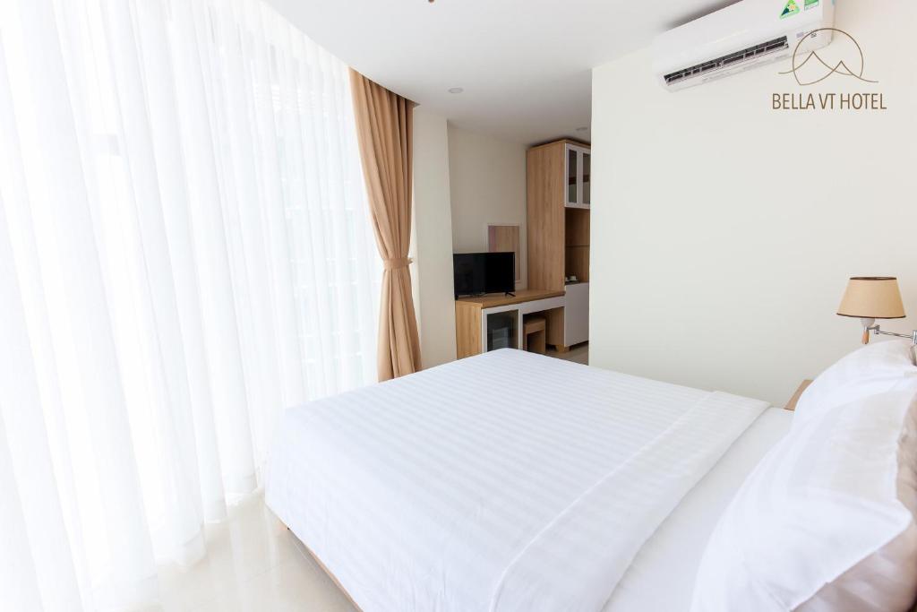 a bedroom with a white bed and a window at BELLA VT HOTEL in Vung Tau