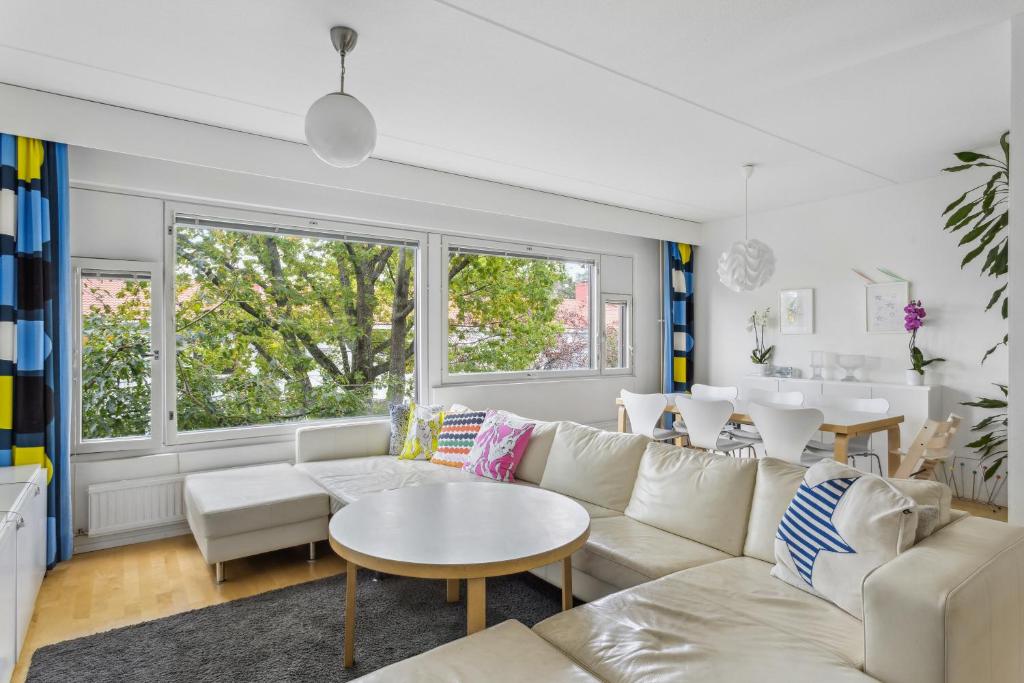 a living room with a white couch and a table at Happy Home Lauttasaari in Helsinki