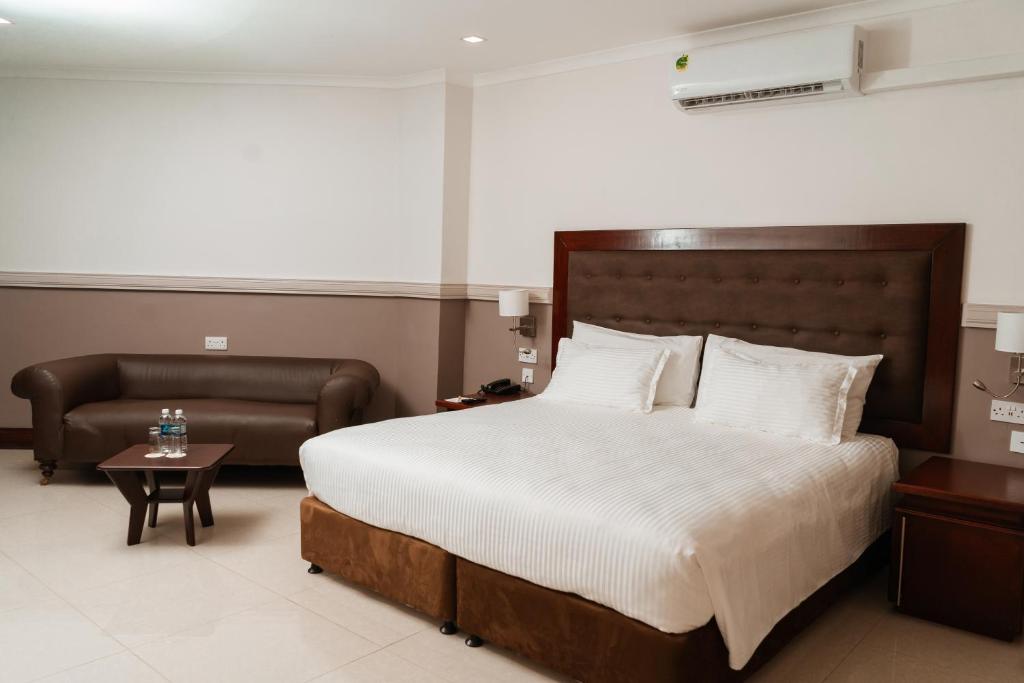 1 dormitorio con 1 cama, 1 silla y 1 mesa en Great Zimbabwe Hotel, en Masvingo