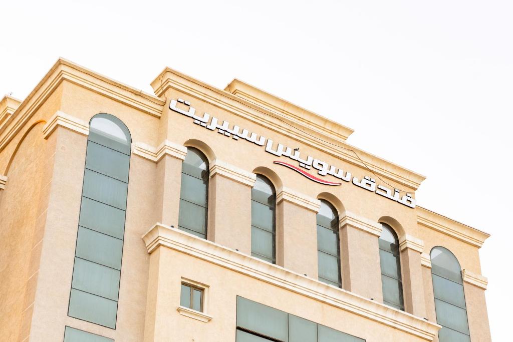 a building with a sign on top of it at Swiss Spirit Hotel & Suites Dammam Corniche in Dammam