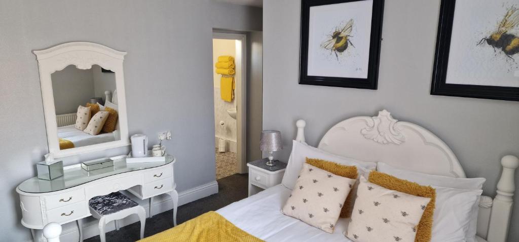 a bedroom with a white bed and a mirror at Hawthorn House in Blackpool