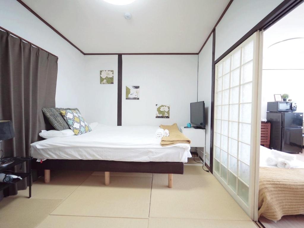 Säng eller sängar i ett rum på Nippori Osaka Nishi-Tengachaya Guesthouse西天下茶屋アパートメント