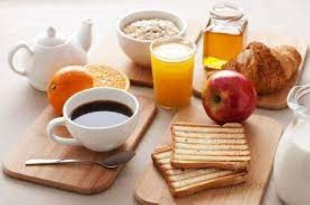 a table with a breakfast of coffee and breakfast foods at The Rooms of Vilmorais - Violette Prince in Arcomps
