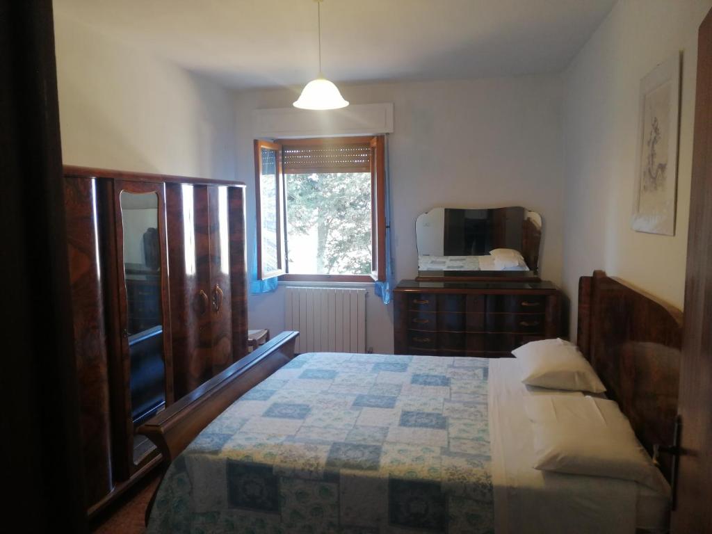 ein Schlafzimmer mit einem Bett, einer Kommode und einem Fenster in der Unterkunft Agriturismo Santa Chiara in Pomarance