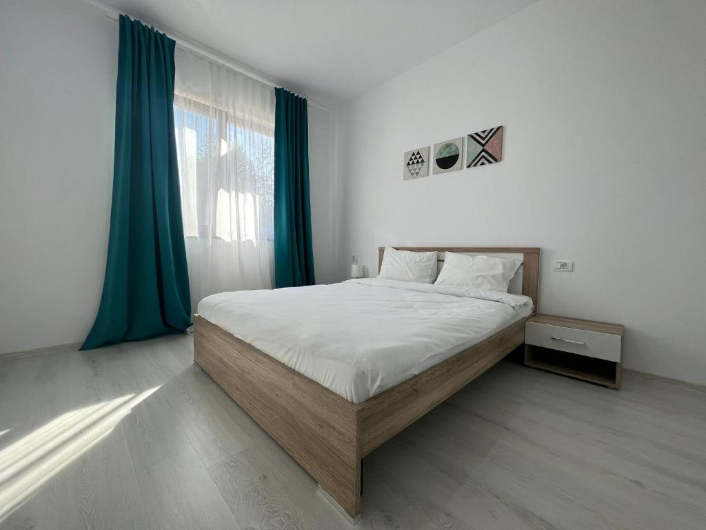a bedroom with a large bed with green curtains at VISAJ Metropolitan - authorized by the Ministry of Tourism in Giroc