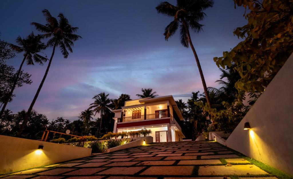 a house with a pathway leading up to it at night at The Vogue - Luxury Private Pool Villa , Athirappilly in Athirappilly