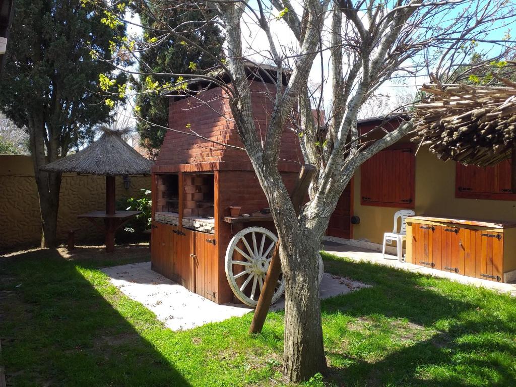 una cabaña de madera con un cañón en un patio en LAS ACACIAS en Mar de Ajó