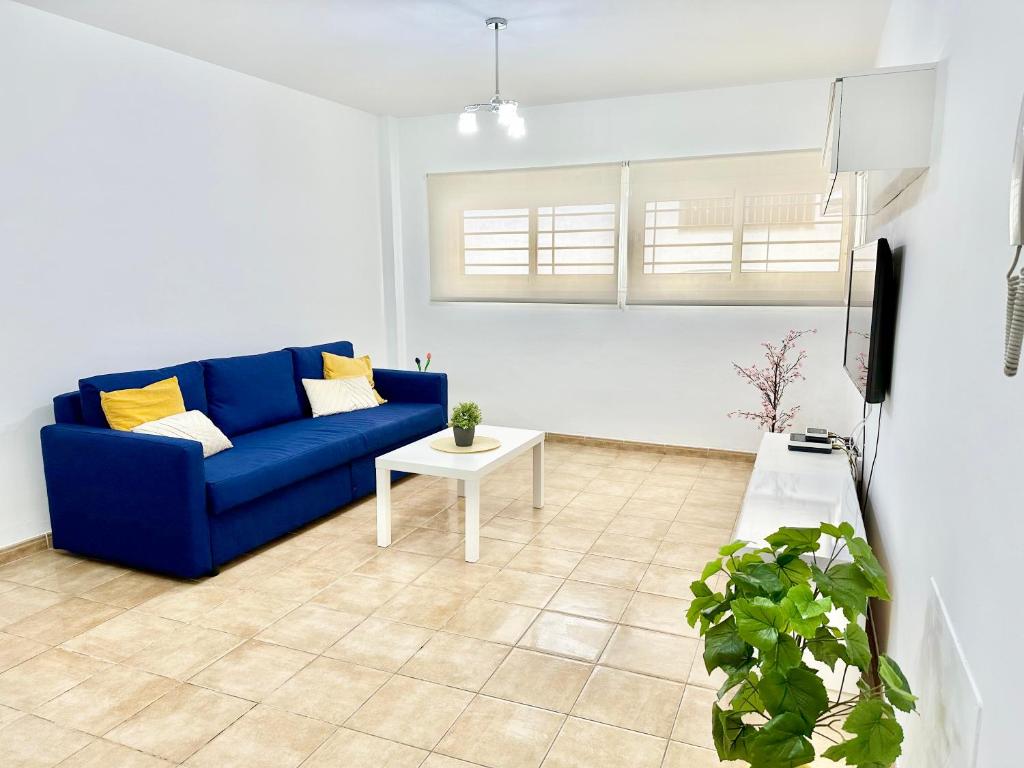un soggiorno con divano blu e tavolo di Apartamento E&D a Nerja