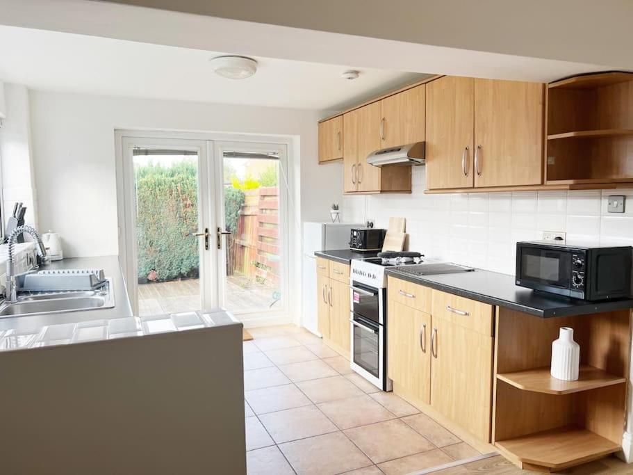 a kitchen with wooden cabinets and a stove top oven at Millfield House by Blue Skies Stays in Middlesbrough