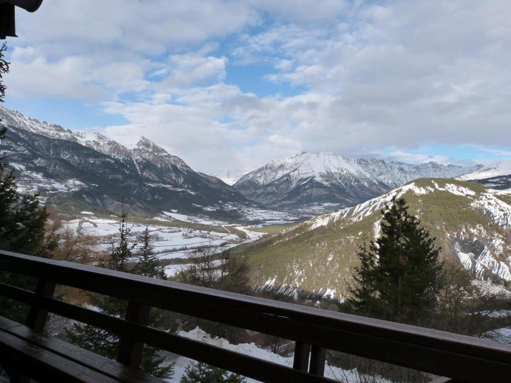 a view of a snowy mountain range from a balcony at Chalet Cèdre Rouge in Enchastrayes