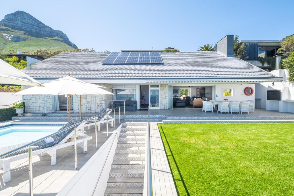 een huis met een zwembad en een huis met een zonnedak bij Clifton Sunset, Does have Power! in Kaapstad