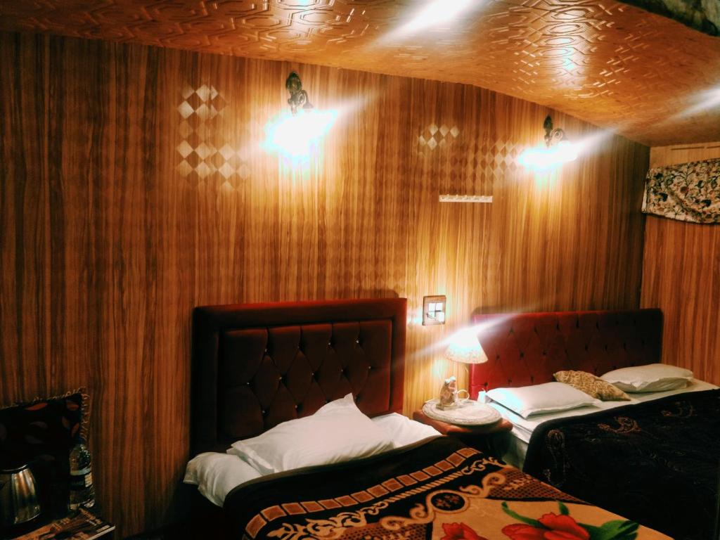 1 dormitorio con 2 camas y 2 luces en la pared en B ,heritage luxury houseboat, en Srinagar