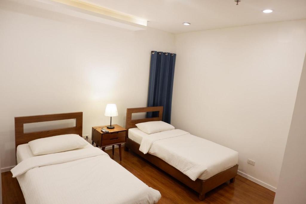 Postel nebo postele na pokoji v ubytování ECCO Suites Baguio