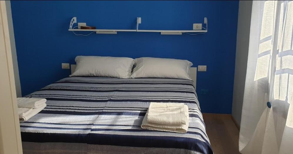 a blue bedroom with a bed with two towels on it at Monteceneri 9 B&b in Rho