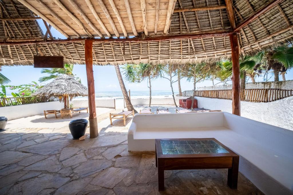 een woonkamer met een bank en uitzicht op het strand bij Beachfront Villa Hideaway ZanzibarHouses in Kiwengwa