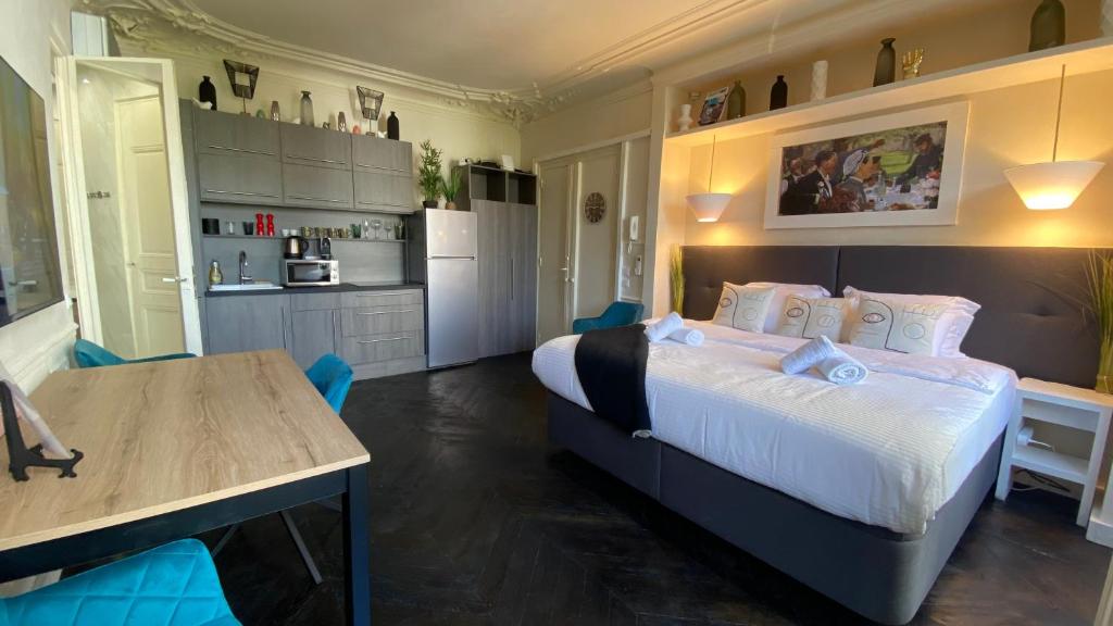 une chambre avec un grand lit et une cuisine dans l'établissement Appartement Bretagne 4 places, à Paris