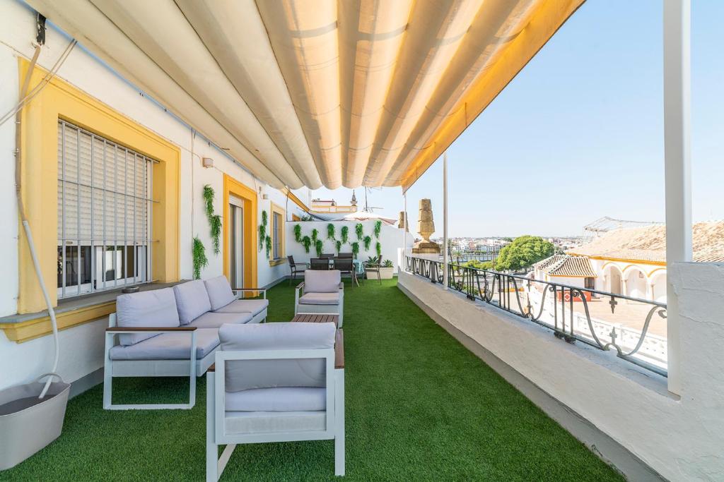 Elle comprend un balcon doté d'un mobilier blanc et d'herbe verte. dans l'établissement Trendy Penthouse by the Bullring, à Séville