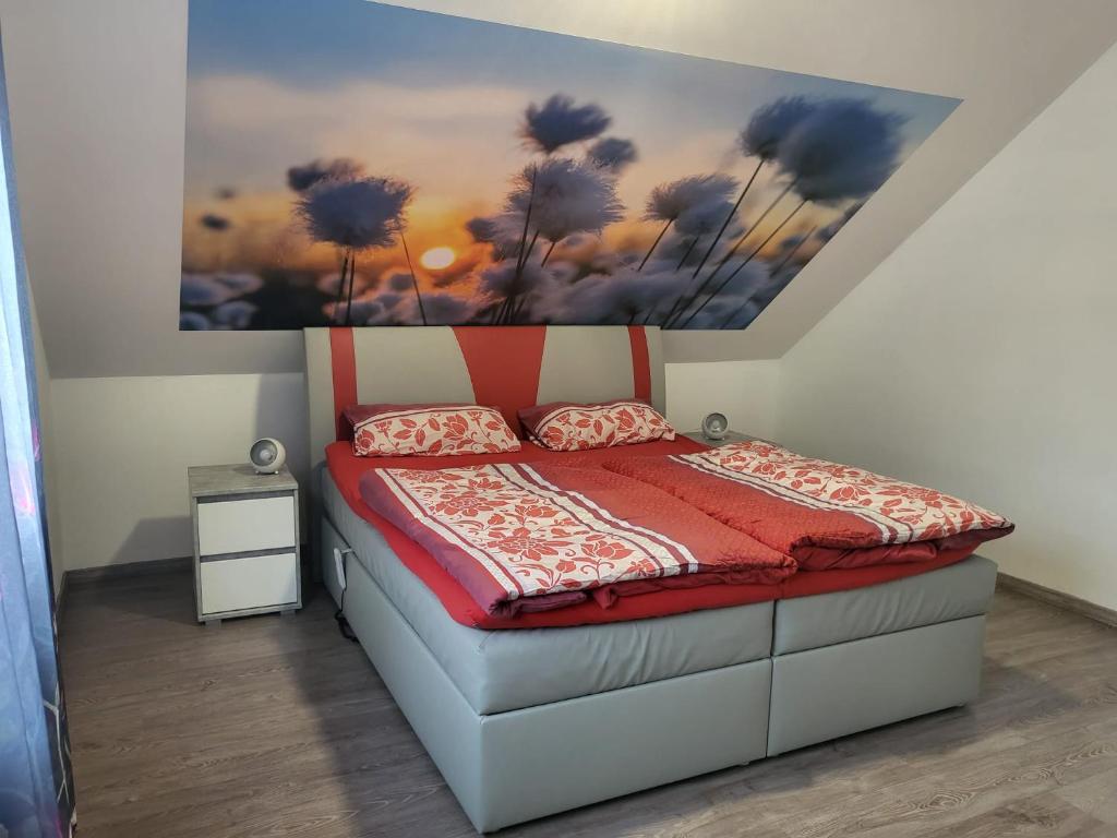Schlafzimmer mit einem Bett mit Wandgemälde in der Unterkunft Ferienwohnung Sabine in Annweiler am Trifels
