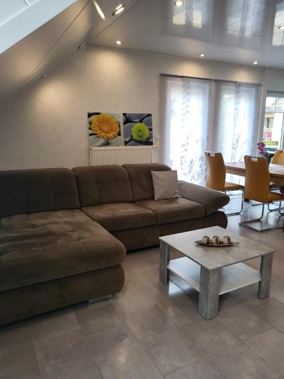 a living room with a brown couch and a coffee table at Ferienwohnung Sabine in Annweiler am Trifels