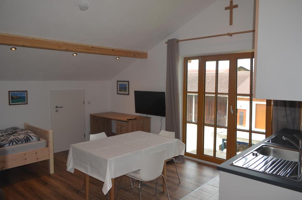 a kitchen with a white table and a cross on the wall at FeWo Rotter Blick in Rott am Inn