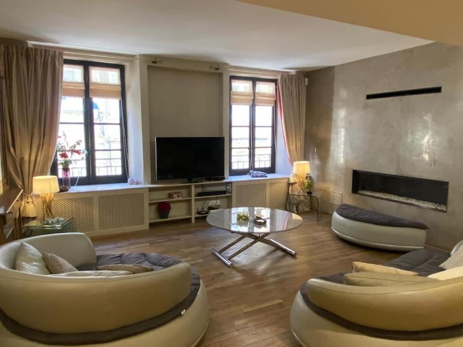 un salon avec deux canapés et une télévision dans l'établissement Le Grand Mazarin T2, à Aix-en-Provence