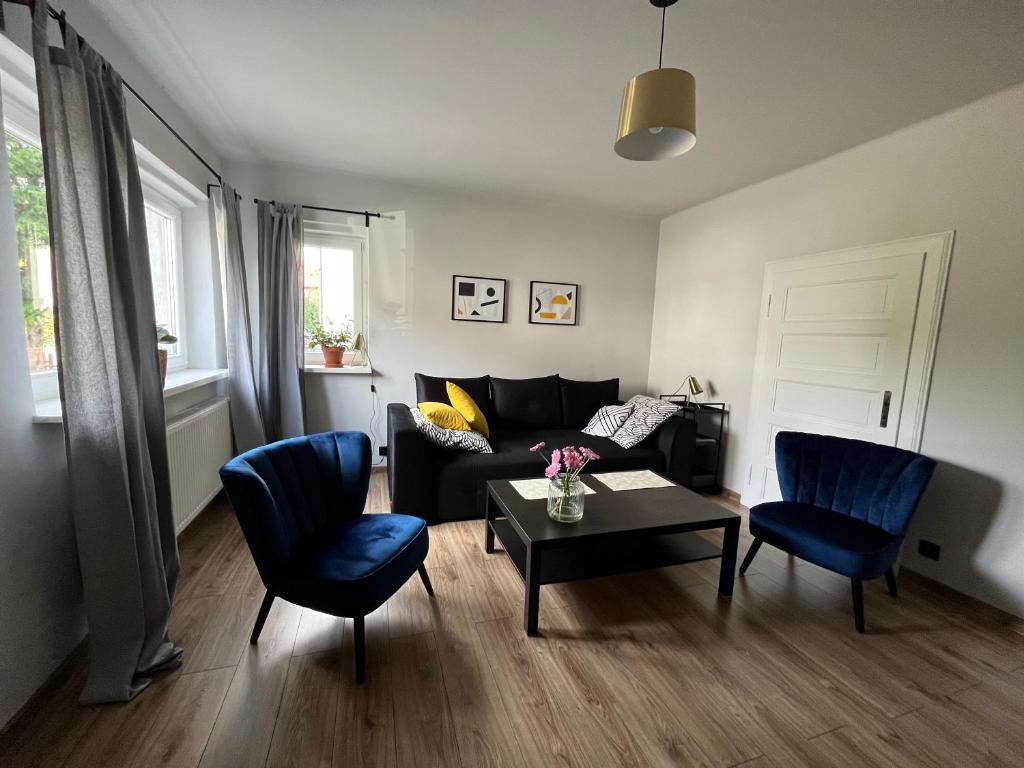ein Wohnzimmer mit einem Sofa, 2 Stühlen und einem Tisch in der Unterkunft Apartament Stanowisko in Gliwice