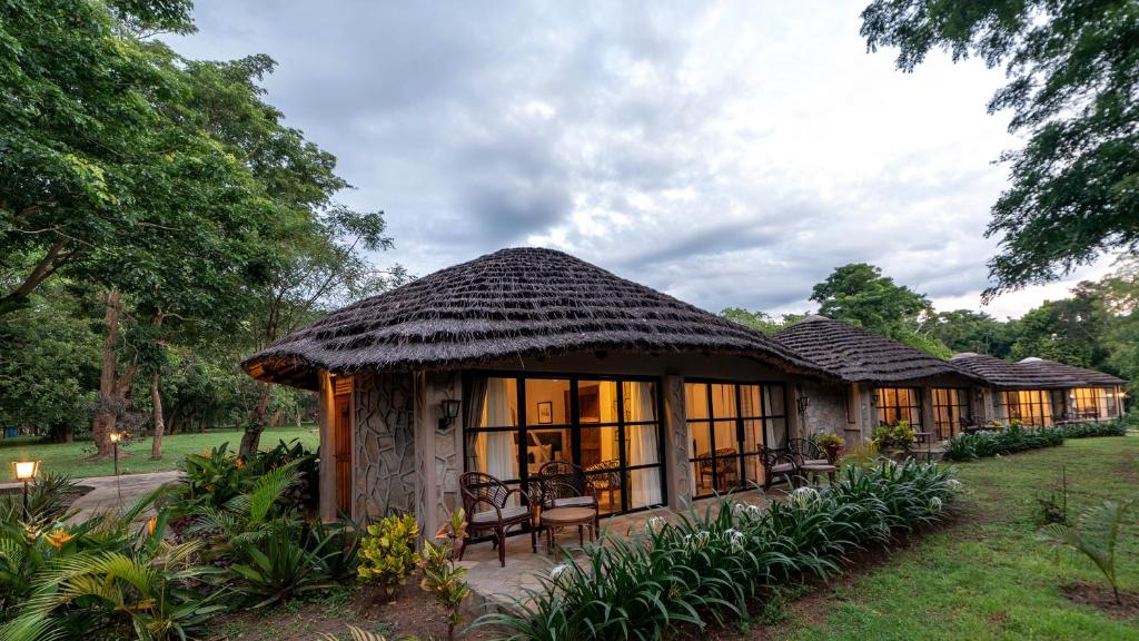 a resort building with a thatched roof at Sambiya River Lodge in Murchison Falls National Park