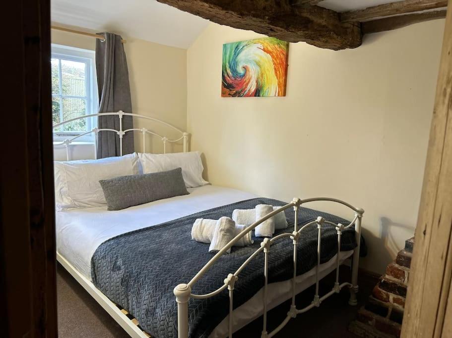uma cama num quarto com um quadro na parede em Entire 3 bedroom Grade 2 listed, close to town centre em Kent