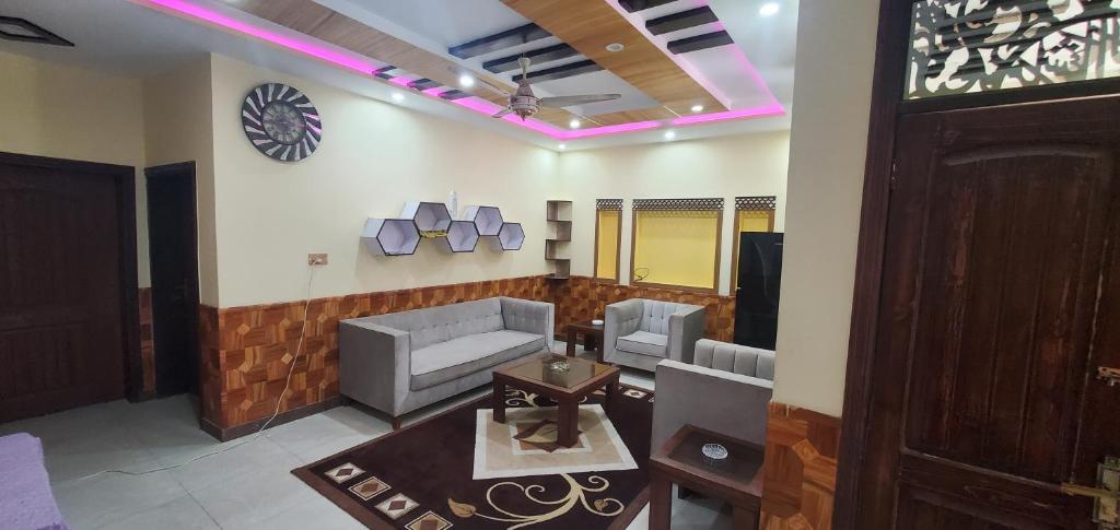 - un salon avec des canapés et une horloge murale dans l'établissement vista guest house, à Quetta