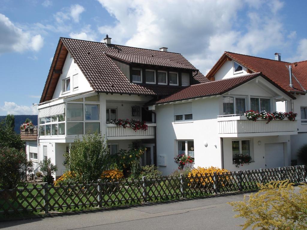a white house with a fence in front of it at Haus Blütenzauber in Sipplingen