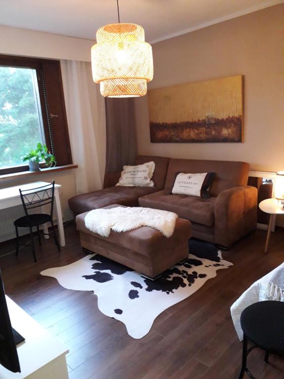 uma sala de estar com dois sofás e um tapete em Meri-Porin lomakoti 