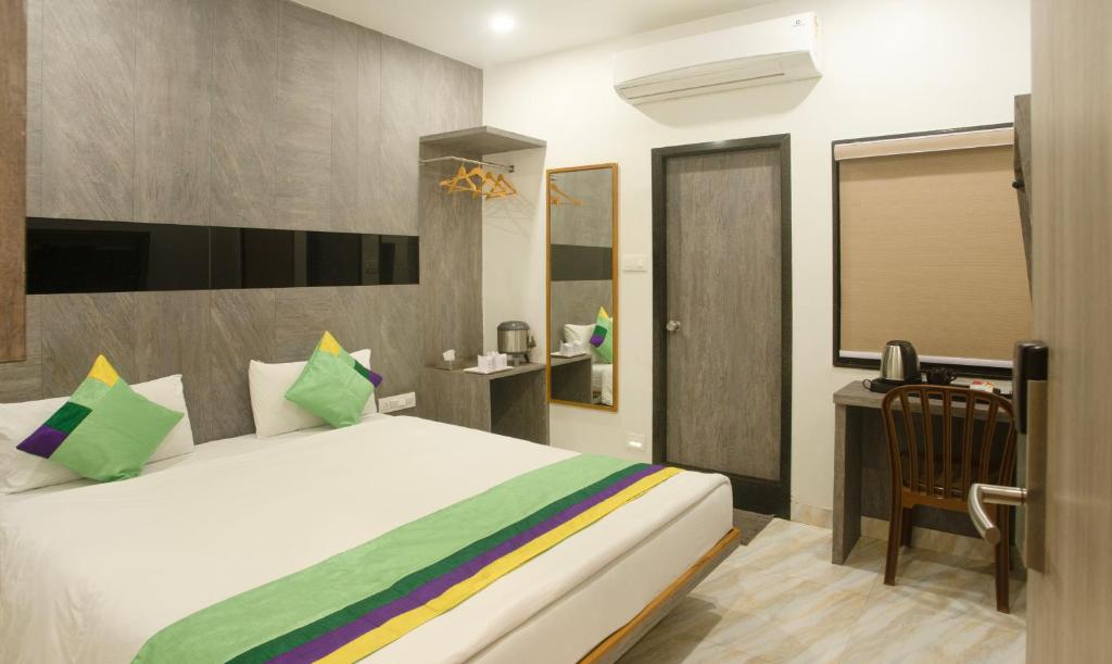1 dormitorio con 1 cama y escritorio en una habitación en Treebo Trend Urban 1 Km From Railway Station, en Surat