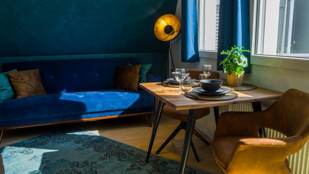 ein Esszimmer mit blauen Wänden sowie einem Tisch und Stühlen in der Unterkunft Ruhig, Zentral & Modern im Herzen Ulms in Ulm