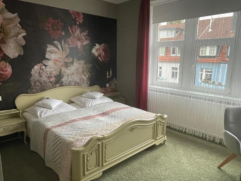 a bedroom with a bed with a floral wallpaper at Hotel Haus Martens in Hannover