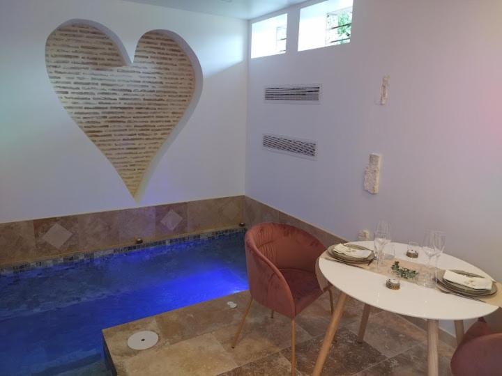 a room with a table and a heart on the wall at Love Room La parenthèse in Saint-Nexans