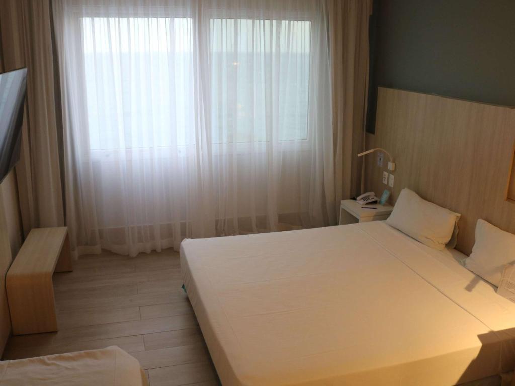 Cama ou camas em um quarto em Mercure Salvador Rio Vermelho